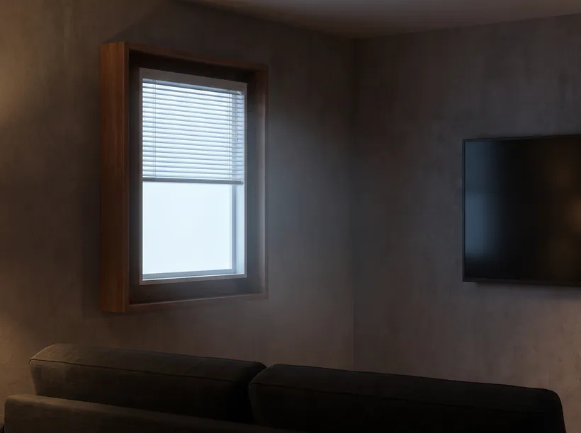 View from the chair in a basement man cave: a framed fake window glowing cool daylight white on the facing wall, the TV hung away from the glow on the side wall
